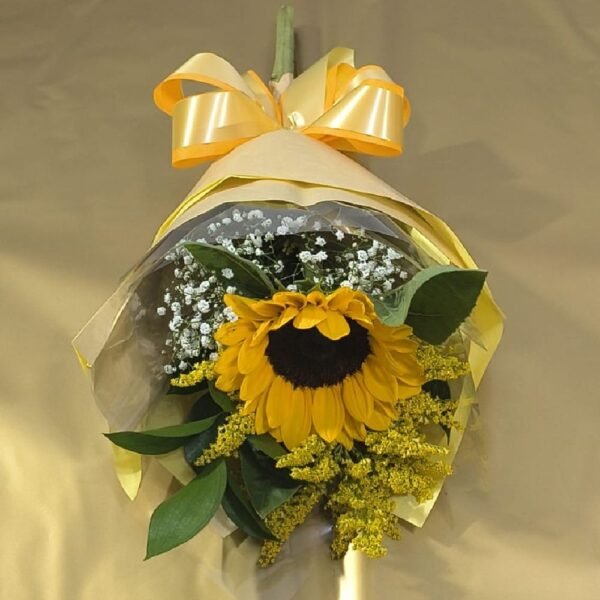 Um girassol decorado com folhagens e laço para presente - Floricultura Curitiba.